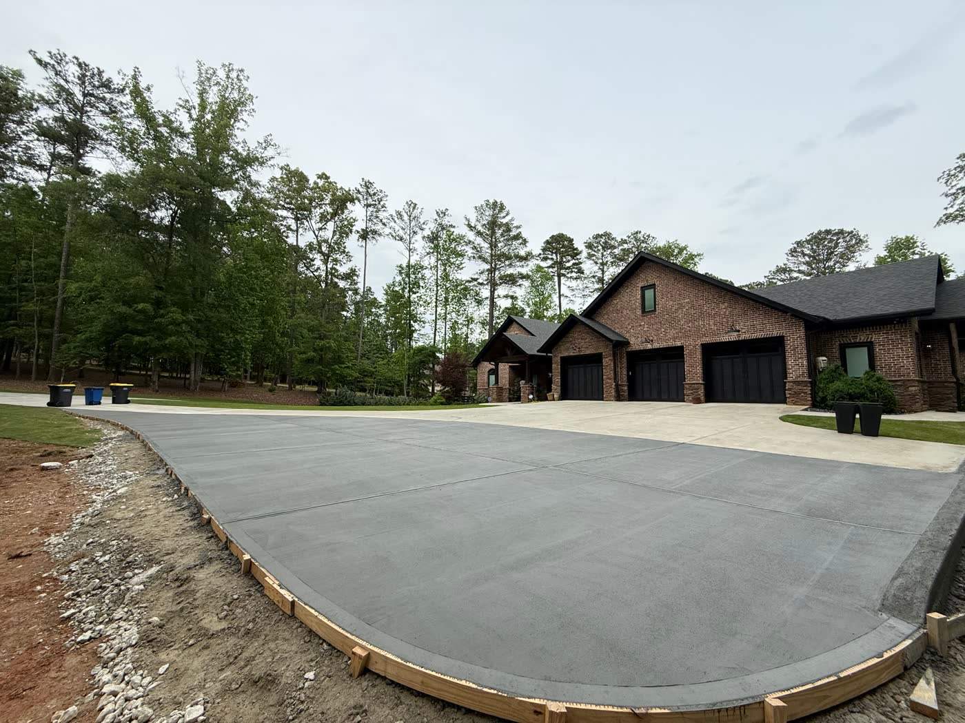 Wide finished concrete slab in front of a new build