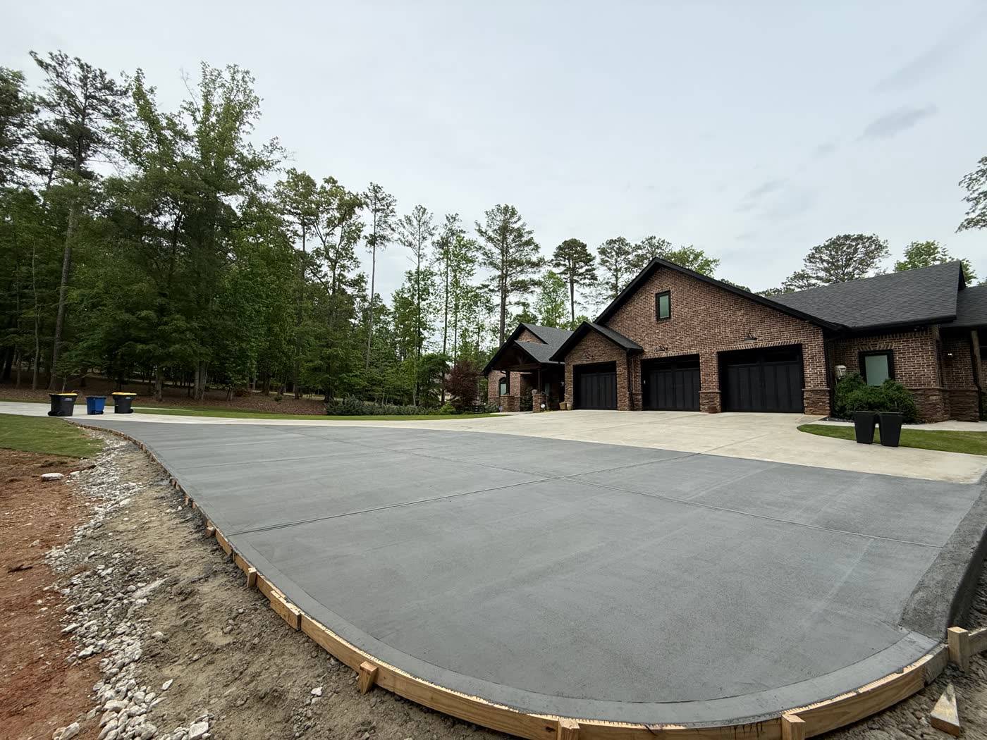 Wide finished concrete slab in front of a new build