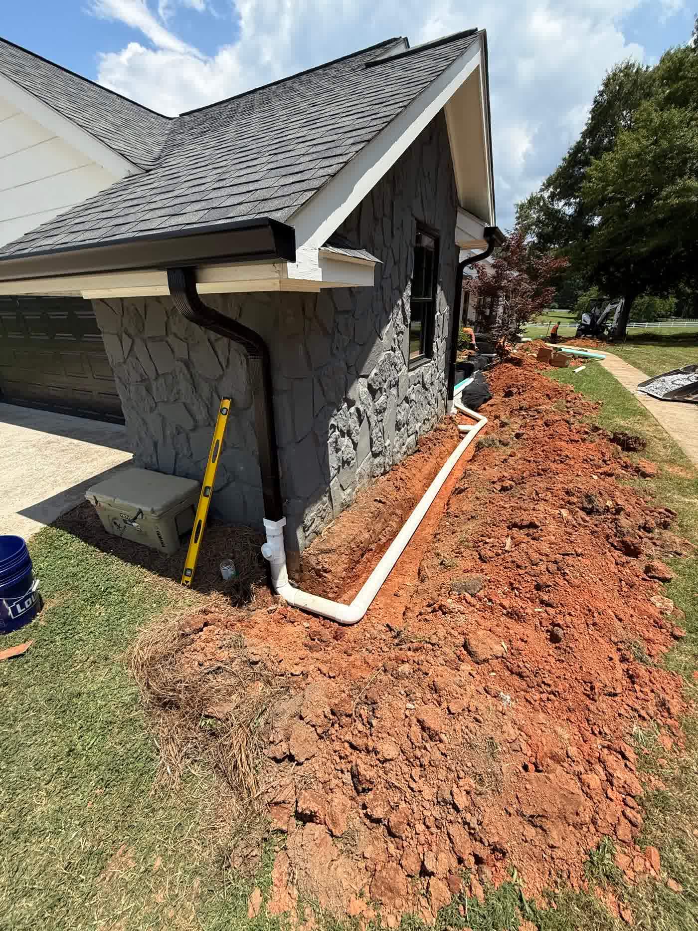 Downspout piped away from the corner of a house