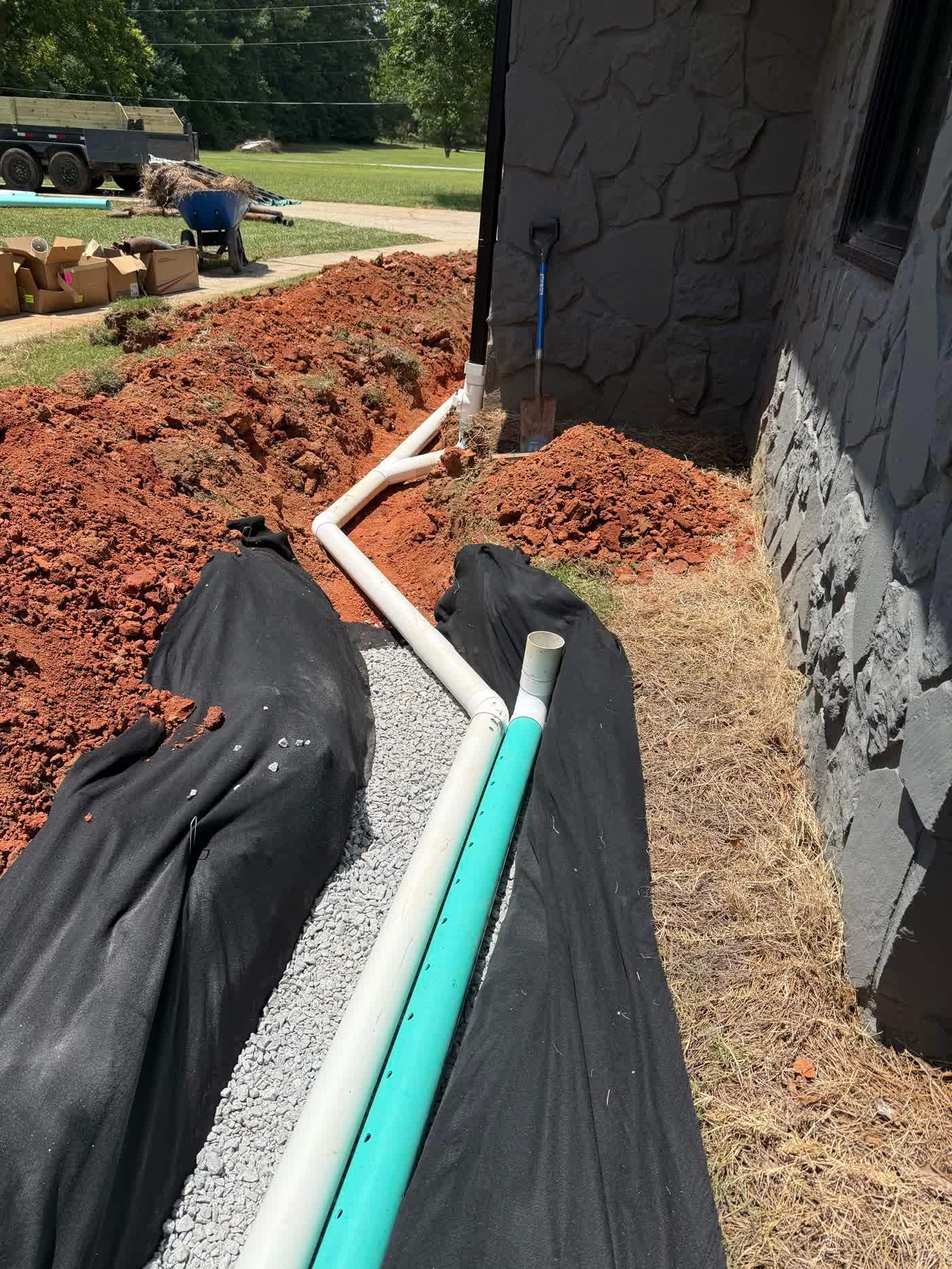 Drain pipe bedded in gravel along a house foundation