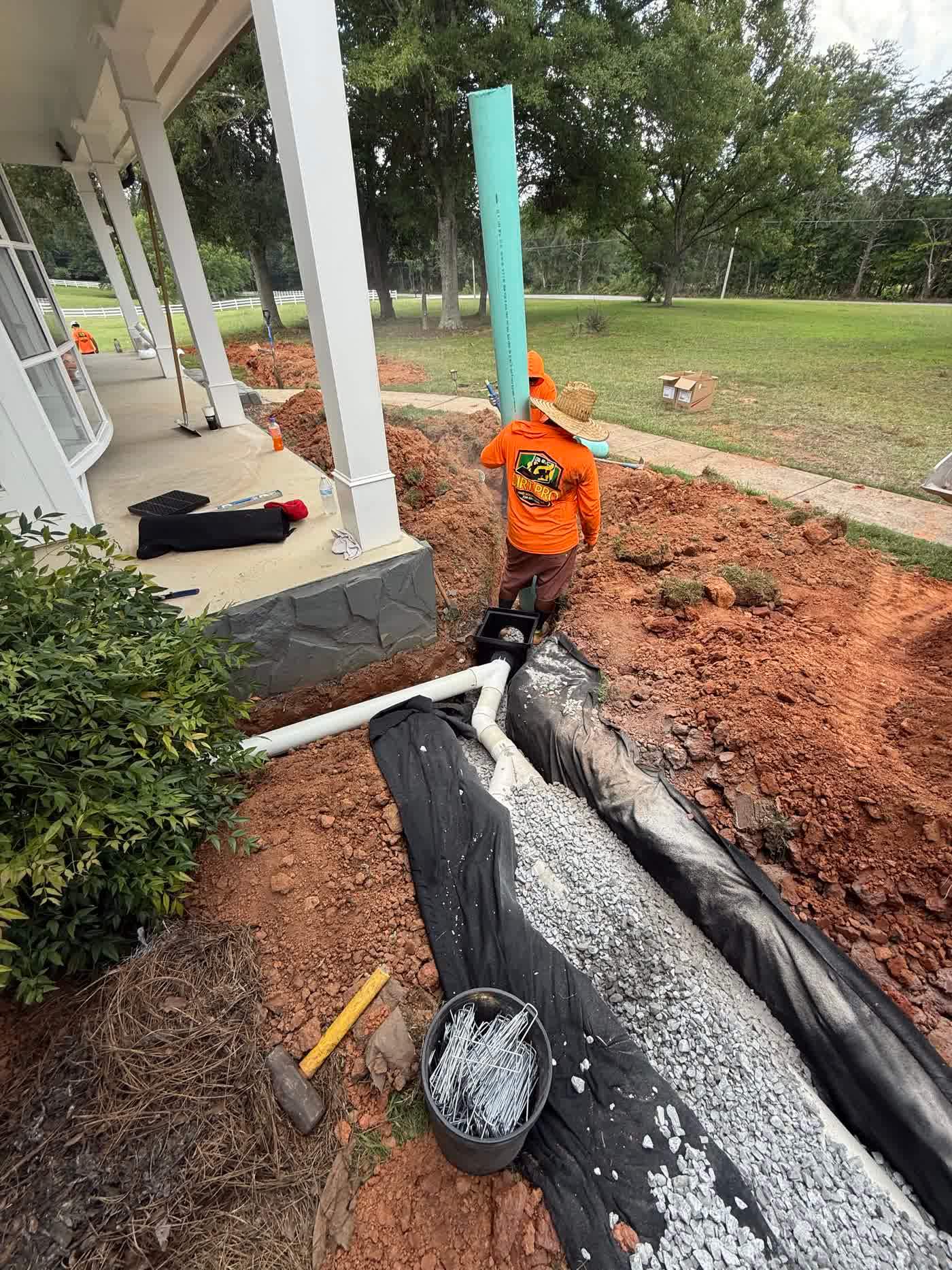 Crew setting drain pipe into an open trench