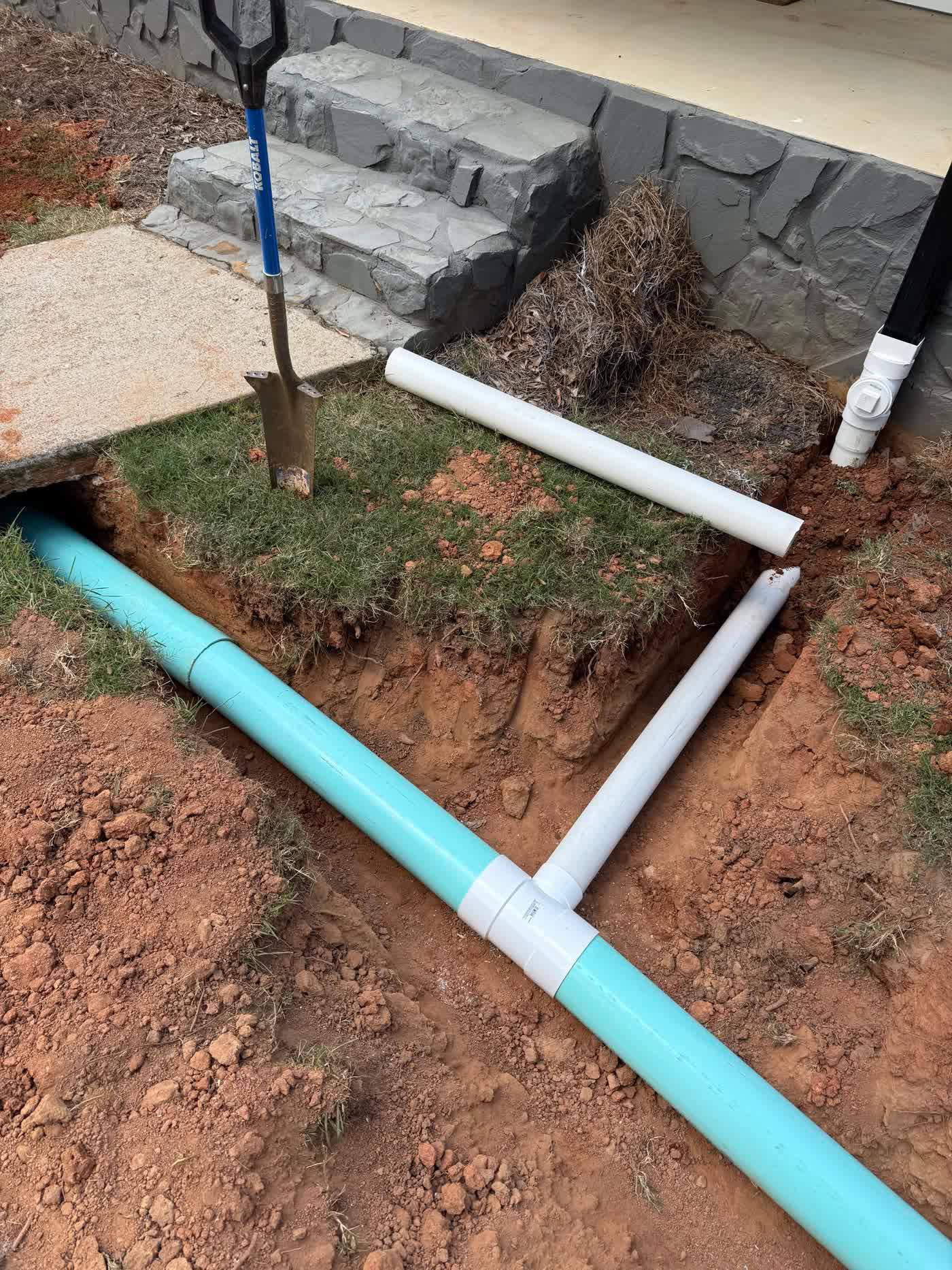 Drain line routed past stone entry steps