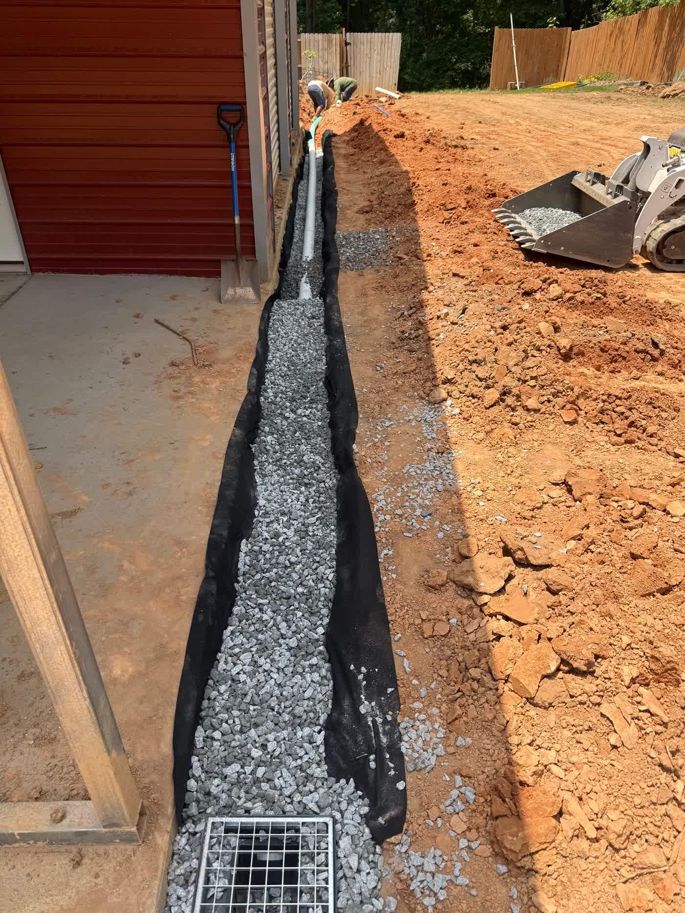 French drain trench lined with filter fabric and drainage stone