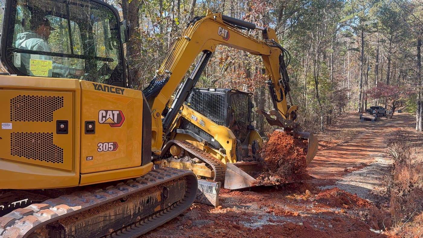 Excavator clearing land on a wooded lot