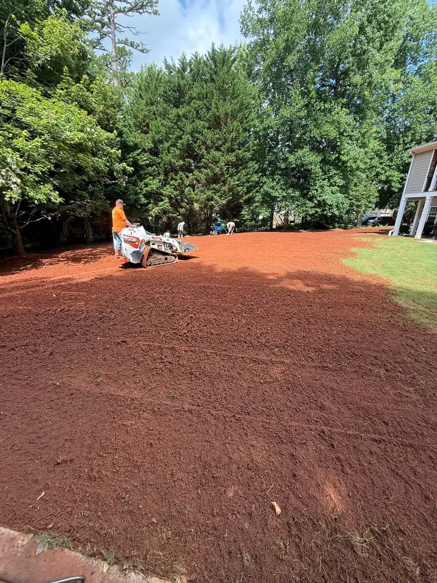 Crew shaping a freshly graded slope on a residential lot