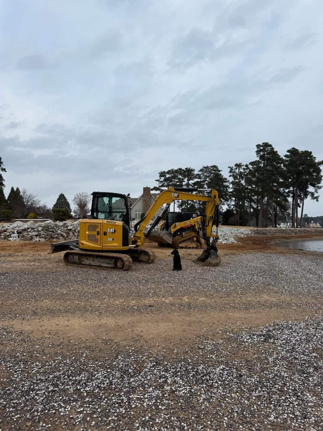 Excavator staged on a gravel area at a job site