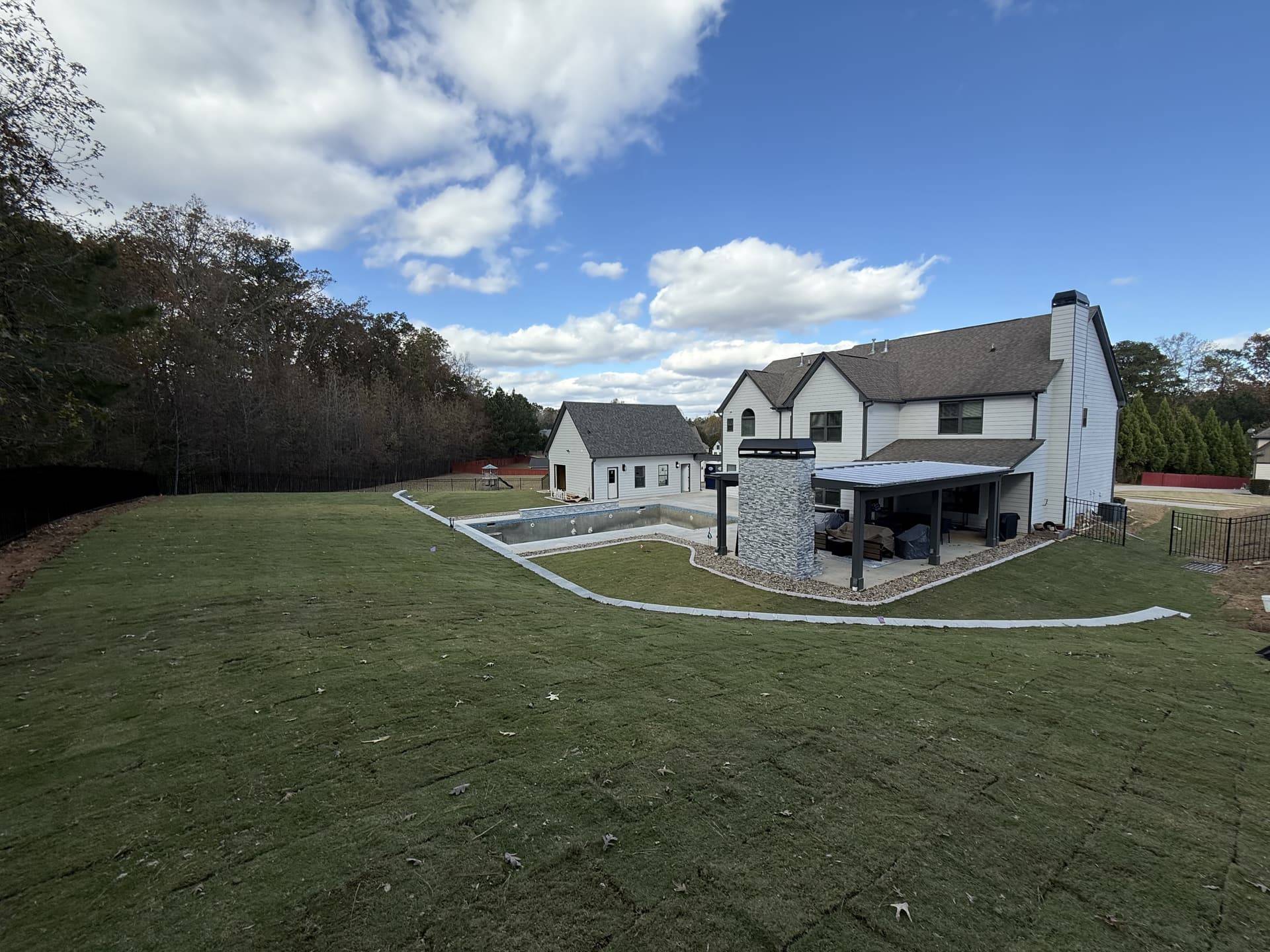 Finished sod lawn and new pool behind a two-story Fayette County home