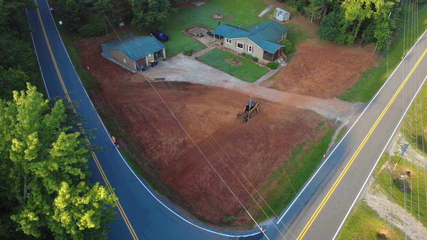 Aerial view of a graded roadside lot before hydroseed