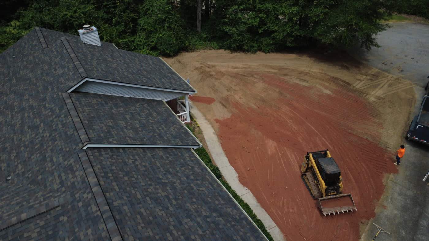 Aerial view of a skid steer working a graded yard