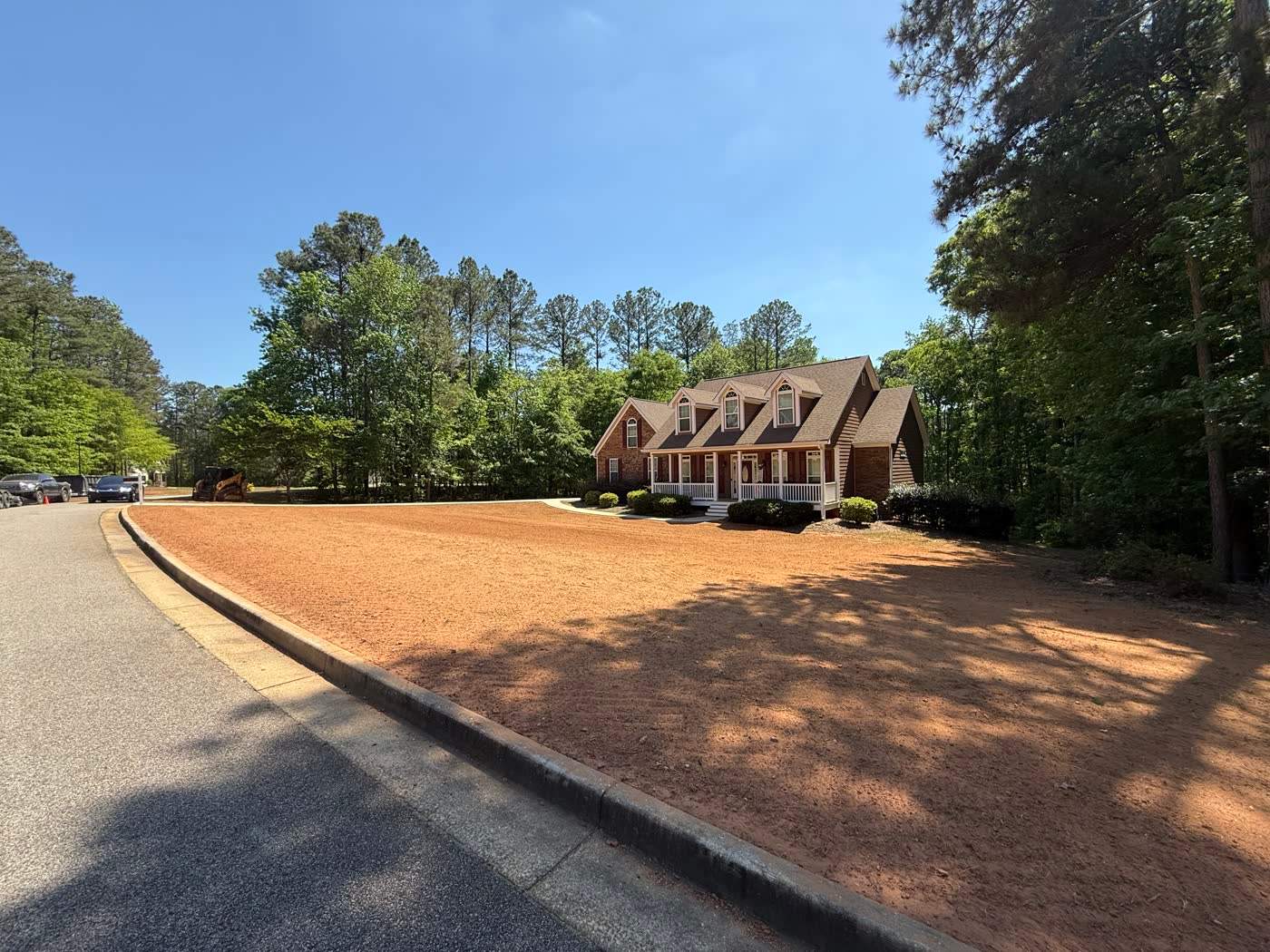 Graded circle drive and yard ready for seed at a brick home