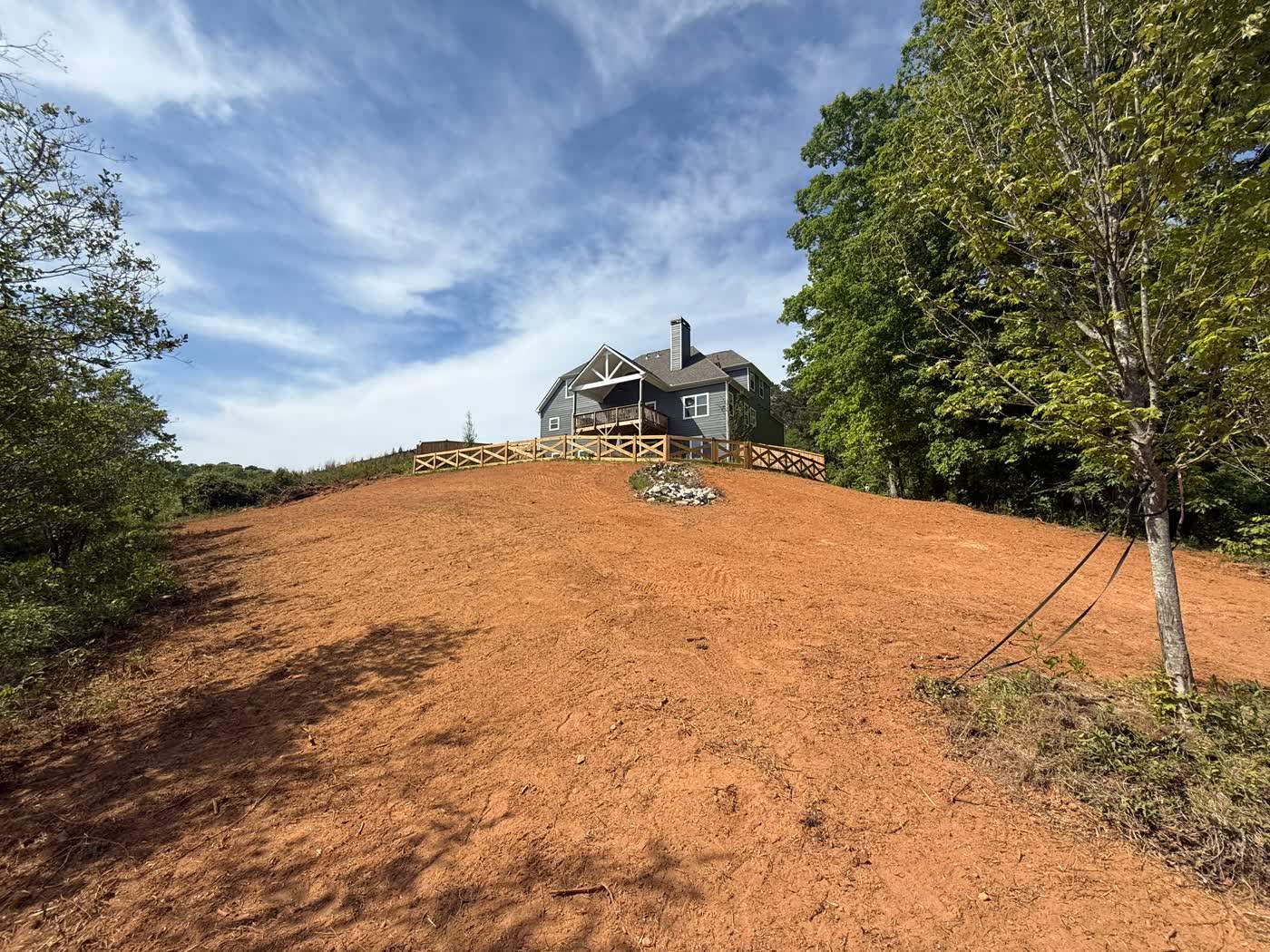 Bare graded hillside prepared for hydroseed beside a home