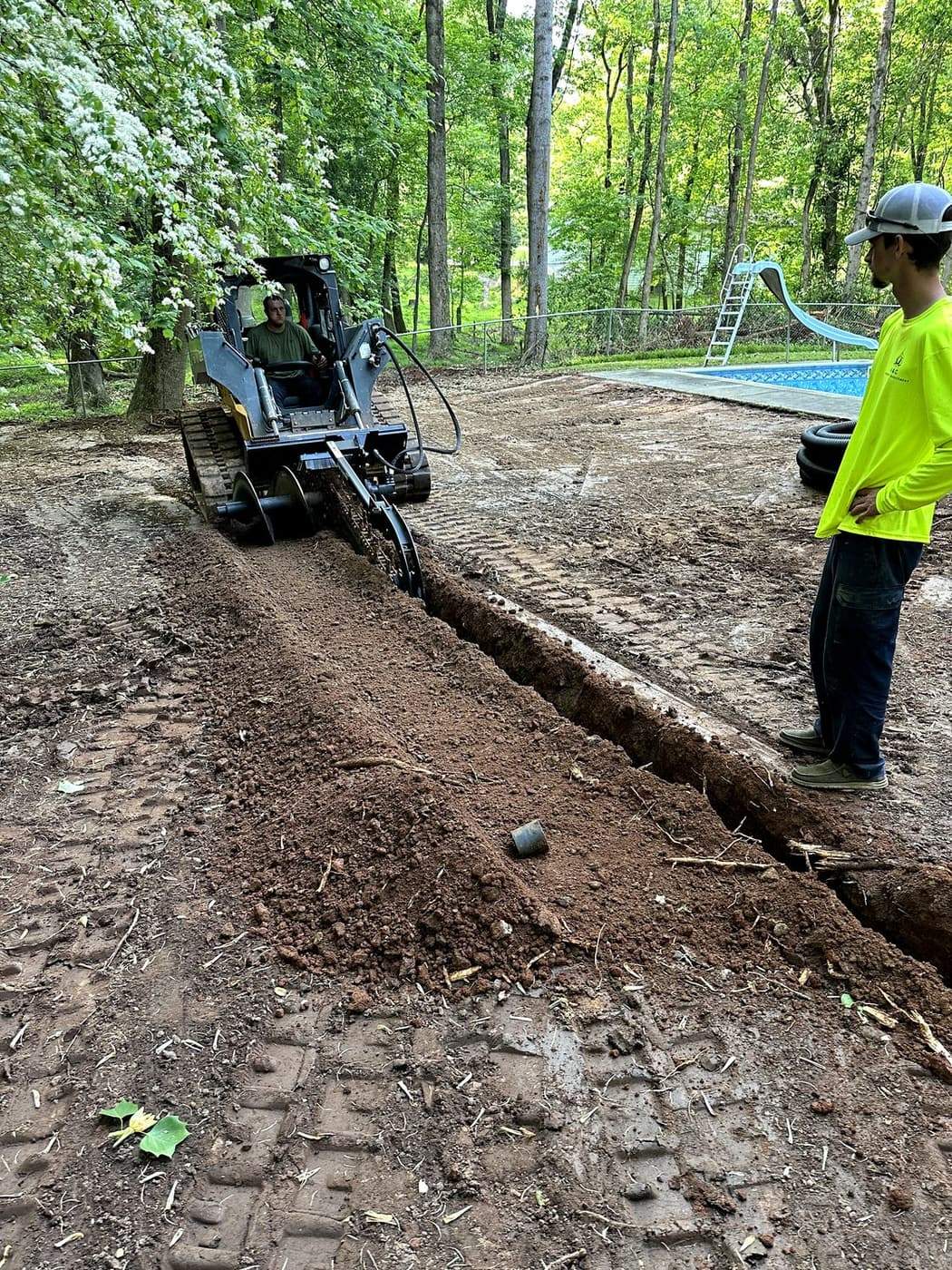 Dirt Pro crew trenching a residential jobsite with a skid steer