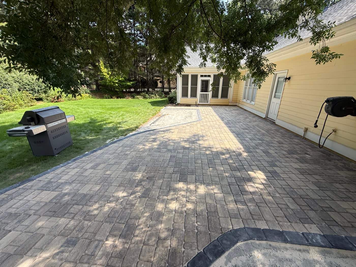 Paver walkway leading to a rear entry door