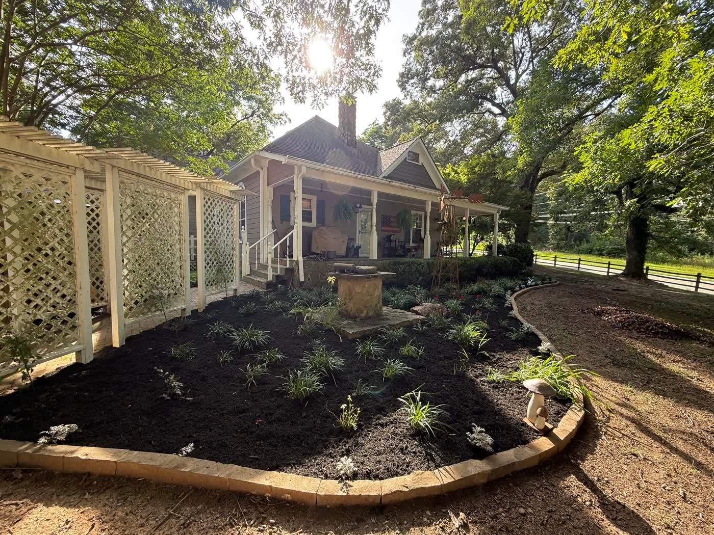 Fresh mulched planting bed beneath a lattice screen
