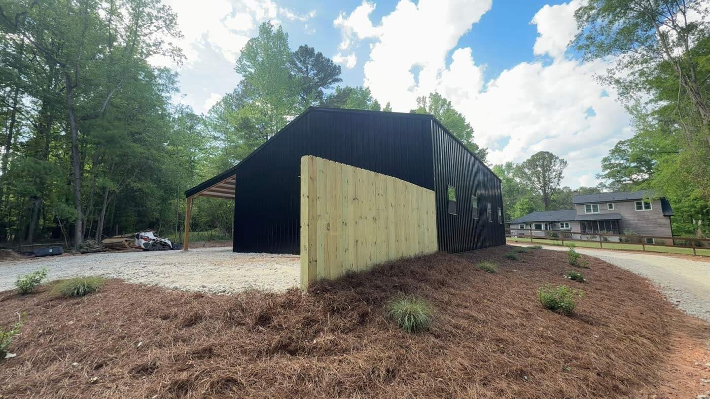 Mulched bed and gravel surround at a black barn