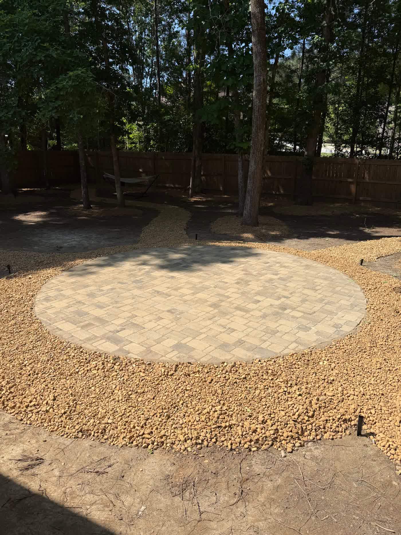 Circular gravel seating area set into a shaded yard