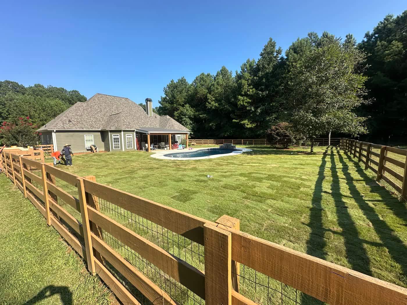 Finished sod lawn inside a fenced pool yard
