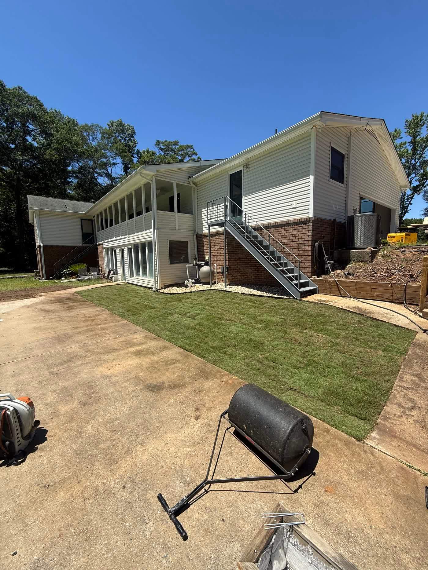 Lawn roller finishing a freshly laid sod lawn