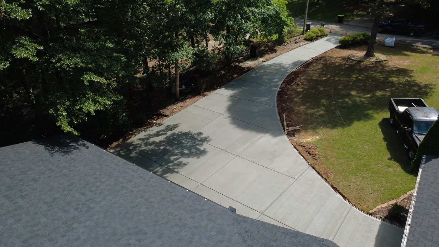 Aerial view of a finished concrete driveway curving to the road