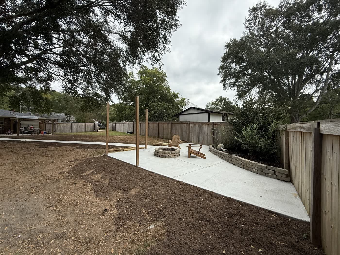 Concrete patio pad with a fire pit and fresh beds