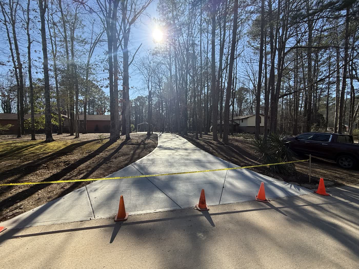 Freshly poured concrete drive taped off through the woods