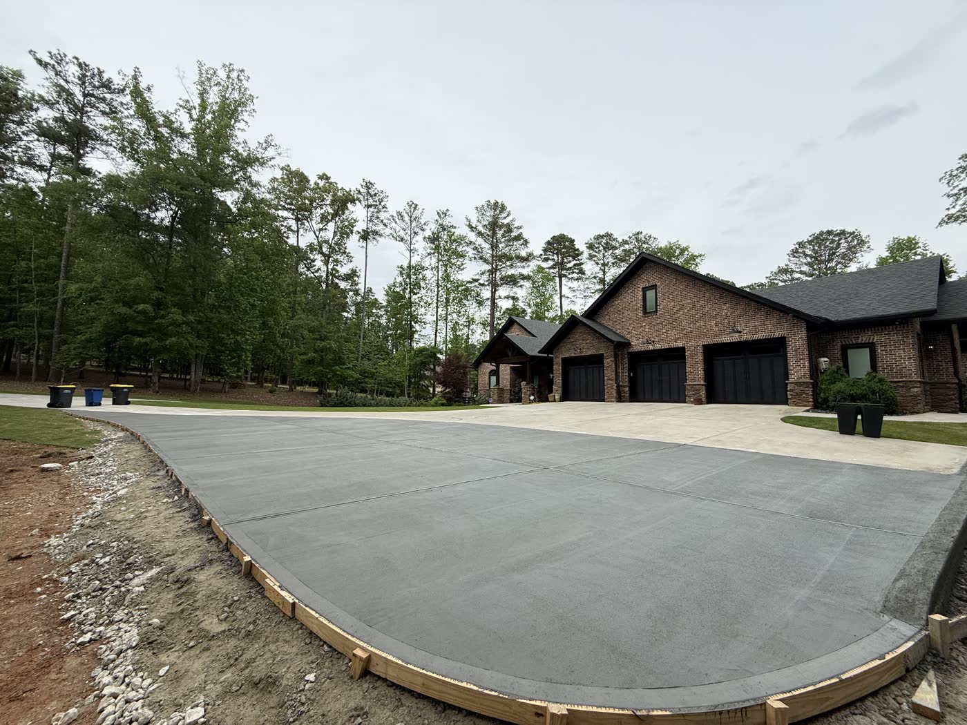 Wide finished concrete slab in front of a new build