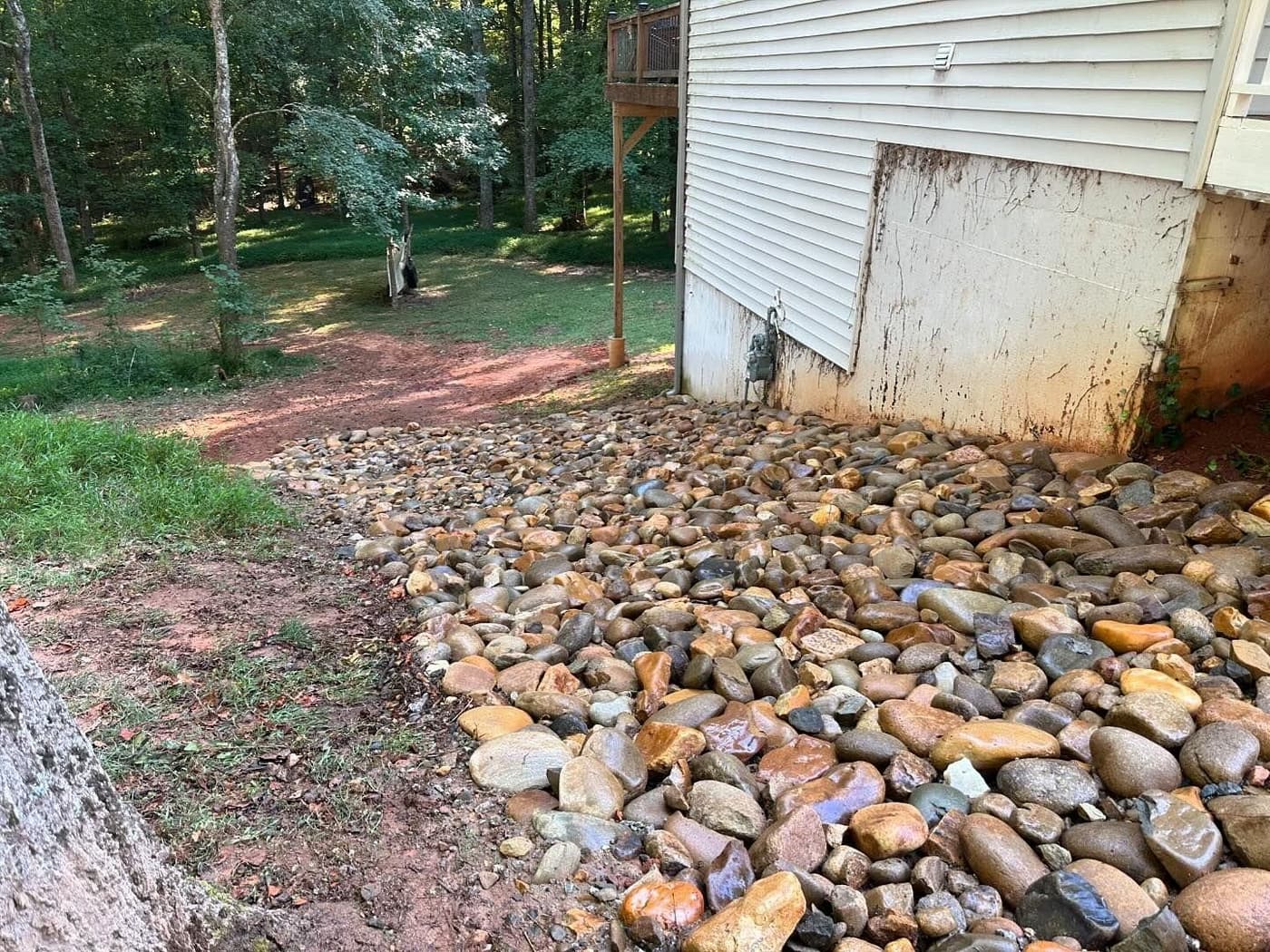 River rock riprap drainage bed along a house foundation