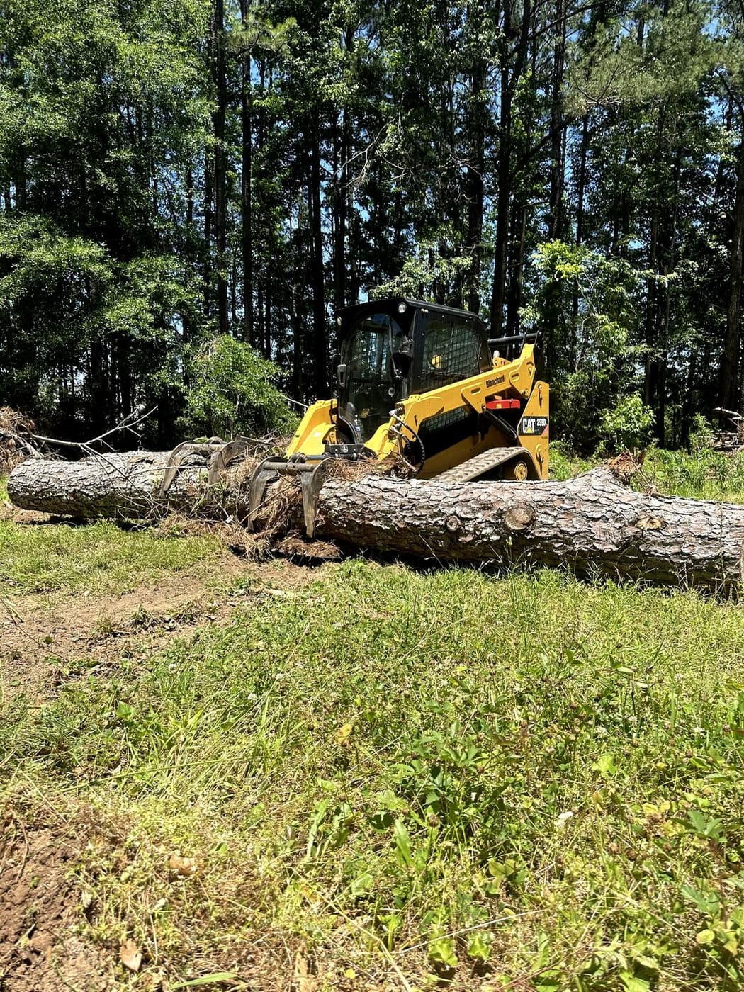 Skid steer trenching across a cleared site